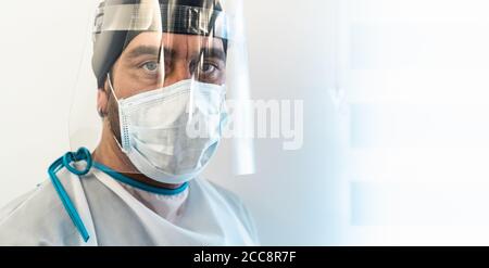 Medico che indossa la maschera chirurgica del viso ppe e visiera che combatte contro l'epidemia di virus corona Foto Stock