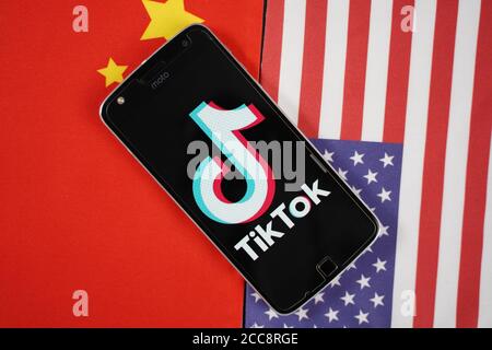 Maski, India 04, Agosto 2020 - il logo dell'app TikTok sullo schermo dello smartphone e posizionato sulle bandiere di Cina e Stati Uniti - l'app è al centro degli Stati Uniti - Cina Foto Stock