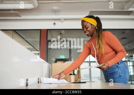 Donna designer africana che lavora sul suo posto di lavoro in ufficio Foto Stock