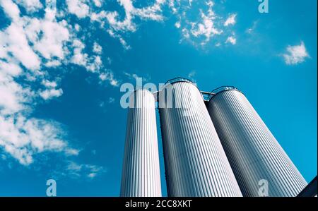 Grandi vasche industriali moderne su sfondo blu cielo. Foto Stock