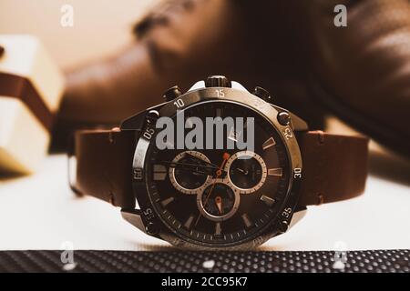 Orologio uomo in pelle marrone con scarpe sullo sfondo Foto Stock