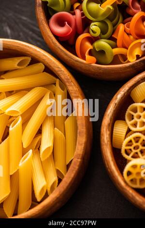 Primo piano vista di varie paste italiane crude in legno ciotole Foto Stock