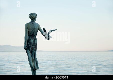 Scultura di una donna con un gabbiano con mare sullo sfondo situato a Opatija, Croazia Foto Stock