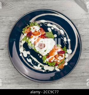 Uovo benedetto con salmone affumicato su pane tostato. Colazione deliziosa Foto Stock