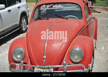 Puerto Vallarta Messico, 19 aprile 2013, un vecchio rosso arrugginito Volkswagen Beetle parcheggiato in strada Foto Stock