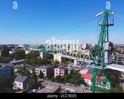 Gru a torre in città in attesa di essere utilizzata. Drone, vista aerea Foto Stock