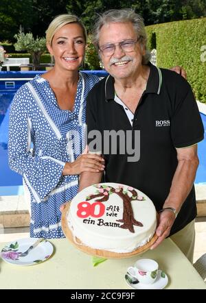 Berlino, Germania. 12 agosto 2020. Burkhard Lasch, compositore, produttore e lirista, sta in piedi alla torta di compleanno con sua figlia, la cantante Tanja Lasch, che è decorato con un albero e la linea di canzone 'Alt wie ein Baum' (Old come un albero). Celebra il suo 80° compleanno il 23.08.2020. Lasch scrisse il titolo di successo 'Alt wie ein Baum' per i Puhdys, 'Jugendliebe' per Ute Freudenberg e quasi 200 titoli noti per band e cantanti famosi. (A ''Old as a tree' - il cantautore della GDR Burkhard Lasch compie 80 anni) Credit: Jens Kalaene/dpa-Zentralbild/ZB/dpa/Alamy Live News Foto Stock