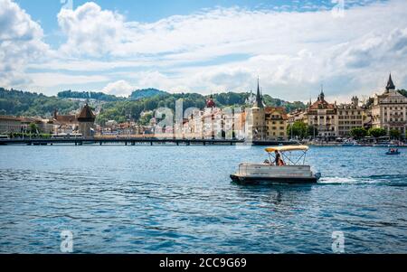 Lucerna Svizzera , 28 giugno 2020 : turisti in barca libera licenza per noleggiare sul lago e la città di Lucerna con monumenti come il ponte della cappella a backgrou Foto Stock