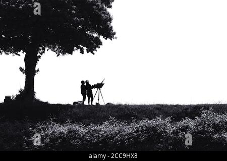 Immagine in bianco e nero, quasi silhouette, di due pittori paesaggistici sotto un albero su una diga in Francia Foto Stock