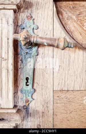 Chiusura dell'antica maniglia della porta corrosa sulla porta di legno Foto Stock