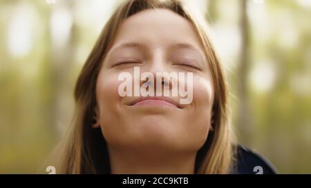 Bellezza naturale. Giovane donna con gli occhi e il sorriso coccolati gode di ai fresco nei boschi. Foto di alta qualità Foto Stock