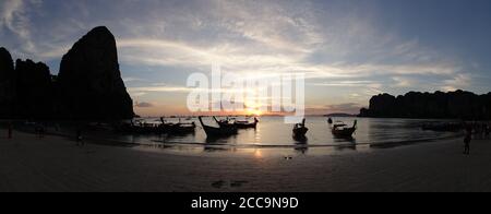 Tramonto sull'oceano con cielo arancione alla spiaggia di Phra nang a Railay, Krabi, Thailandia. Foto Stock