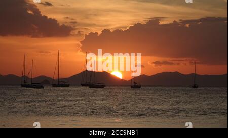 Tramonto sull'oceano con cielo arancione alla spiaggia di Phra nang a Railay, Krabi, Thailandia. Foto Stock