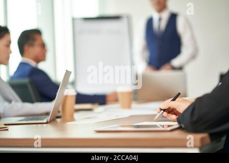 i dirigenti aziendali asiatici si riunono in ufficio per discutere del piano aziendale Foto Stock