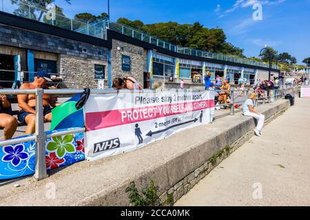 Banner sul lungomare: Si prega di stare a 2 metri di distanza. Lyme Regis, una popolare località balneare sulla Costa Jurassic a Dorset, nel sud-ovest dell'Inghilterra Foto Stock