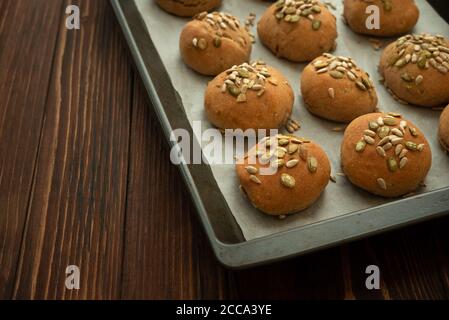 Panini croccanti freschi fatti in casa con crusca, girasole e semi di zucca su una teglia da forno. Vista dall'alto. Foto Stock