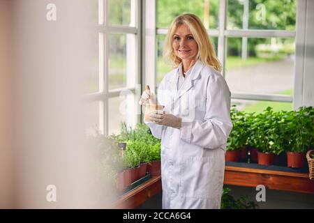 Compiaciuta donna botanica che lavora in un laboratorio Foto Stock