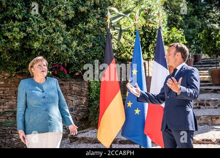 Bormes Les Mimosas, Francia. 20 Agosto 2020. Emmanuel Macron (r), Presidente della Francia, dà il benvenuto alla Cancelliera Angela Merkel (CDU) al suo arrivo nella residenza estiva del Capo di Stato, il Forte di Bregancon. L'ex fortezza si trova su una roccia sulla costa mediterranea vicino Tolone. Credit: Michael Kappeler/dpa/Alamy Live News Foto Stock