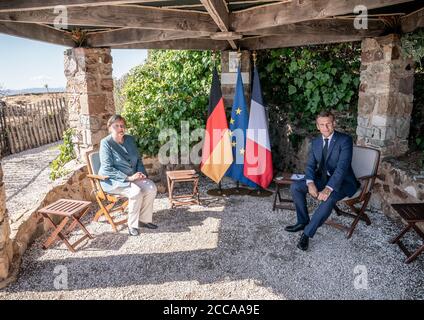 Bormes Les Mimosas, Francia. 20 Agosto 2020. Emmanuel Macron, Presidente della Francia, parla con la cancelliera Angela Merkel (CDU) nel giardino della residenza estiva del Capo di Stato, il Forte di Bregancon. L'ex fortezza si trova su una roccia sulla costa mediterranea vicino Tolone. Credit: Michael Kappeler/dpa/Alamy Live News Foto Stock