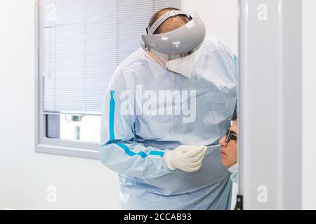 Bologna, Italia. 20 Agosto 2020. Il 20 agosto 2020 a Bologna, in Italia, un medico si sottopone a uno striscio presso la stazione di prova corona per i rimpatriati in vacanza all'aeroporto internazionale di Bologna. Oggi, all'interno dell'aeroporto, è stata aperta su base sperimentale una stazione mediale per eseguire il tampone nasofaringeo per COVID-19 per i viaggiatori provenienti da Paese considerato a rischio (Croazia, Grecia, Malta e Spagna). Credit: Massimiliano Donati/Alamy Live News Foto Stock