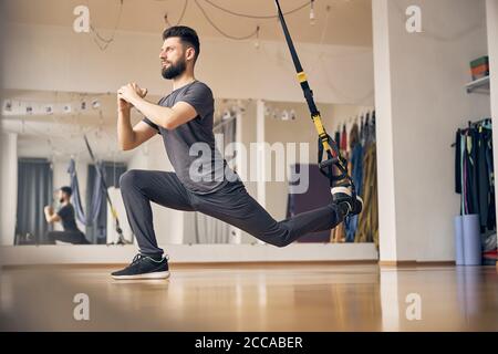 Il giovane atleta sognante si sta affondo in interni Foto Stock