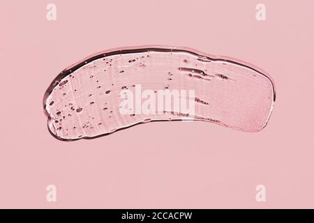 Gel liquido trasparente su sfondo rosa. Striscio ruvido con bolle di ossigeno. Foto Stock