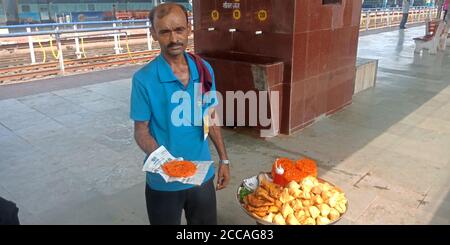 DISTRETTO KATNI, INDIA - 15 SETTEMBRE 2019: Un uomo indiano che offre spuntini galebi all'angolo del cibo di strada alla stazione ferroviaria. Foto Stock