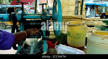 DISTRETTO SATNA, città di MAIHAR, INDIA - 12 SETTEMBRE 2019: Un uomo indiano che macina il succo di canna da zucchero dalla macchina che funziona a mano su strada. Foto Stock
