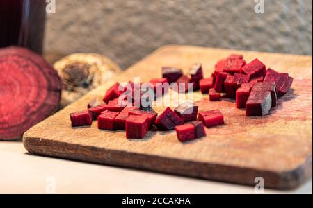 Barbabietola (Beta vulgaris L.) tagliata su una tavola di legno accanto a tuberi rotti. Verdure per insalate. Verdure usate nella cucina brasiliana. Fonte di zucchero pr Foto Stock