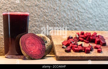 Barbabietola (Beta vulgaris L.) tagliata su una tavola di legno accanto a tuberi rotti. Verdure per insalate. Verdure usate nella cucina brasiliana. Fonte di zucchero pr Foto Stock