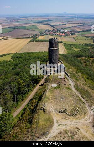 Ruines del castello di Hazmburk in cima alla cima della catena montuosa di ceske stredohori. Vista dalla torre bianca sulla torre nera e il paesaggio. Foto Stock