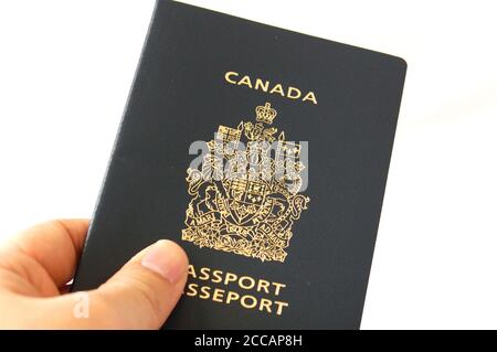 Tenere in mano o consegnare il passaporto canadese a qualcuno Foto Stock