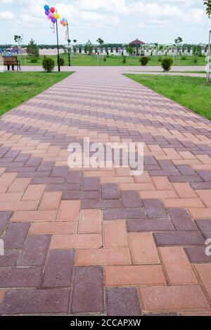 Moldavia, Bender - 18 maggio 2019: Lastre di pavimentazione rosse colorate nel parco della città di Bender. Foto Stock