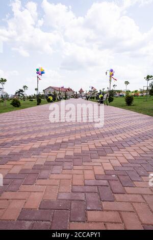 Moldavia, Bender - 18 maggio 2019 la strada è lastricata di lastre rosse colorate nel parco Bender. Orientamento verticale. Foto Stock