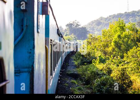 Goa, India. Paesaggio della natura in India. Vista di un treno da un treno. Il tramonto intorno ad un fiume nella regione di Goa mentre si viaggia in treno per Mumba. Foto Stock