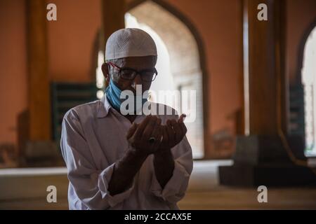 Un uomo Kashmiri che indossa una maschera facciale è visto pregare all'interno di Jamia masjid in Srinagar.Authorities in indiano amministrato Kashmir riaperto luoghi religiosi quasi dopo 5 mesi dopo la chiusura come misura preventiva contro la diffusione del coronavirus (COVID-19). Foto Stock