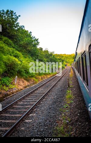 Goa, India. Paesaggio della natura in India. Vista di un treno da un treno. Il tramonto intorno ad un fiume nella regione di Goa mentre si viaggia in treno per Mumba. Foto Stock