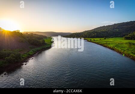 Goa, India. Paesaggio della natura in India. Vista di un treno da un treno. Il tramonto intorno ad un fiume nella regione di Goa mentre si viaggia in treno per Mumba. Foto Stock