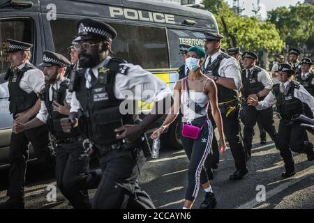 Durante il Lockdown, i poliziotti incontrati si precipitano davanti a un protestore BLM a Londra. Foto Stock