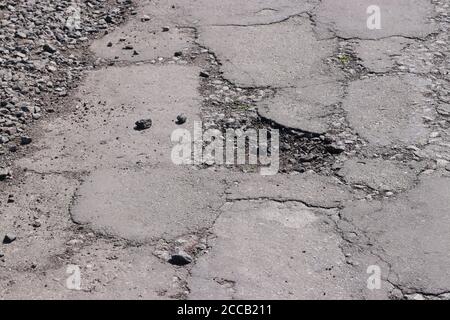 Autostrada con buchi su strade ucraine, asfalto rotto Foto Stock