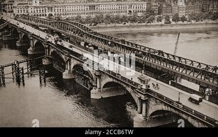 Waterloo Bridge attraversa il Tamigi tra Blackfriars Bridge e Hungerford Bridge, a Londra. Per motivi di sicurezza, il London County Council decise di demolire il ponte e di sostituirlo con una nuova struttura progettata da Sir Giles Gilbert Scott negli anni trenta. Il progetto è stato messo in sospeso a causa della seconda guerra mondiale, ma è stato installato un ponte di acciaio temporaneo. Foto Stock