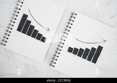 analisi di business e concetto statistico, tendenze positive e negative sui grafici dei notebook affiancati Foto Stock