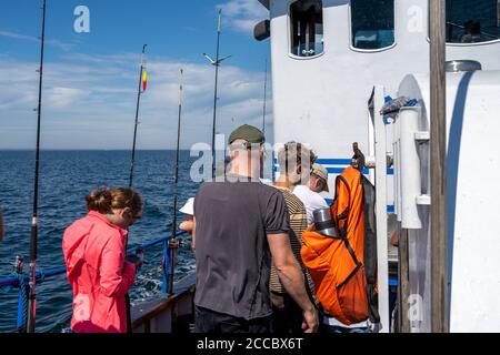 Malmo, Svezia - 6 agosto 2020: Persone in un viaggio di pesca in cerca di Codfish e sgombro. Oceano blu e cielo sullo sfondo Foto Stock