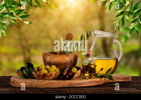 Appena raccolte le olive frutti di bosco in ciotole di legno e olio pressato in bottiglie di vetro. Ancora la vita di preparazione del cibo servito su vecchie tavole di legno. Libera spac Foto Stock