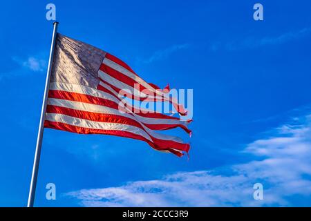 08.08.2013, Berlino, Stelle e strisce, una bandiera degli Stati Uniti d'America che sventola nel vento in una versione estremamente frantumata come simbolo di uno stato disperato degli Stati Uniti contro un cielo blu e leggermente nuvoloso. La bandiera mostra sette strisce rosse e sei strisce bianche, che stanno per i 13 stati fondatori, e un campo bandiera blu nell'angolo in alto a sinistra, le cui attualmente 50 stelle bianche simboleggiano i 50 stati degli Stati Uniti. | utilizzo in tutto il mondo Foto Stock