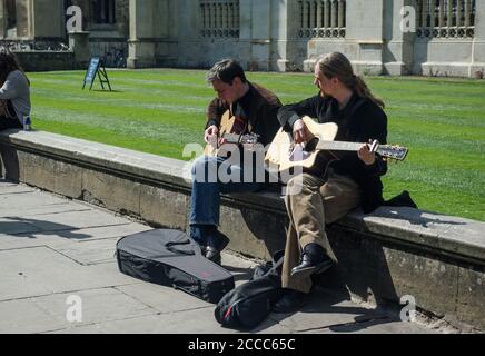 Due musicisti di strada suonano chitarre nel centro della città, Cambridge, Regno Unito Foto Stock