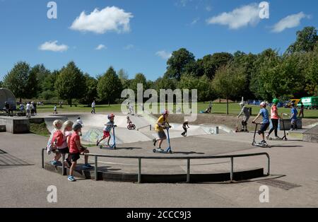 Summer Skatepark - Bambini che guardano e giocano sui loro scooter A Reigate Priory Park Skatepark a Reigate Surrey 2020 - messa a fuoco in primo piano Foto Stock