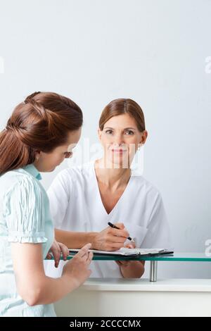 Il medico anziano compila un modulo con un paziente Foto Stock