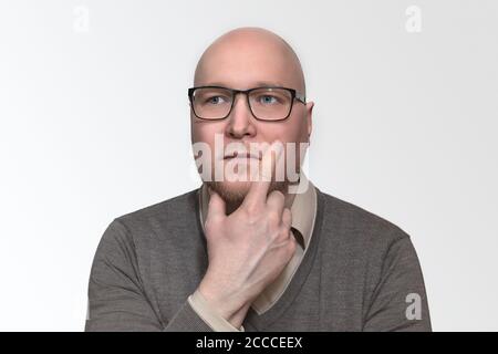 Ritratto di uomo d'affari pensivo in occhiali e abbigliamento casual intelligente, pensa ai problemi Foto Stock