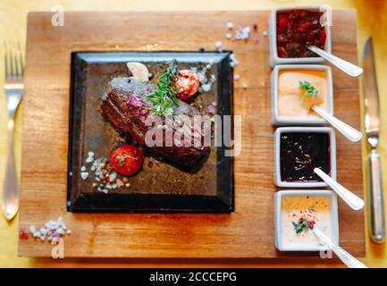 Il cibo del ristorante. Carne di maiale alla griglia il piatto con verdure fresche. Medaglioni con erbe e spezie. Foto Stock